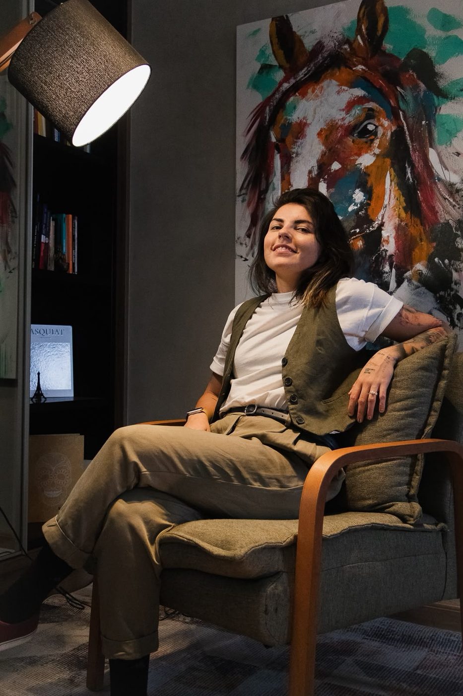 Pâmela Machado em seu ateliê, com a obra Ímpeto ao fundo